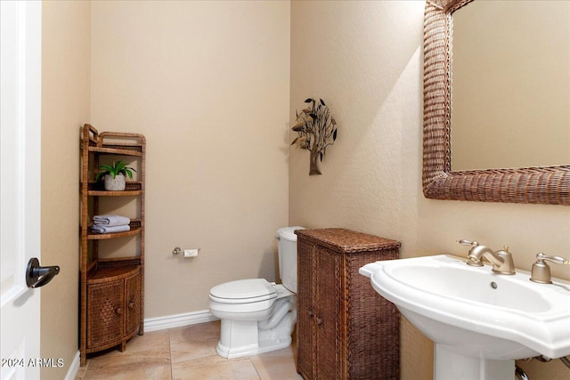 bathroom featuring toilet, sink, and tile patterned floors