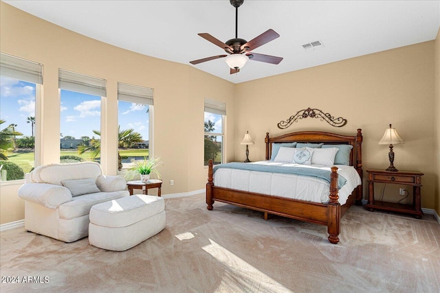 carpeted bedroom with multiple windows and ceiling fan