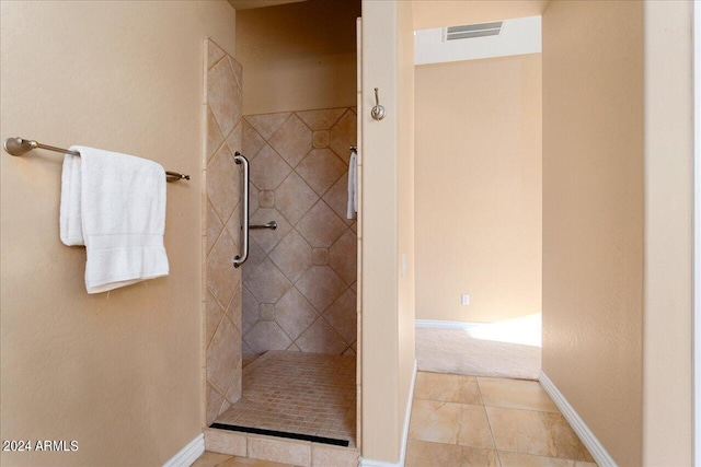 bathroom featuring tile patterned flooring and tiled shower