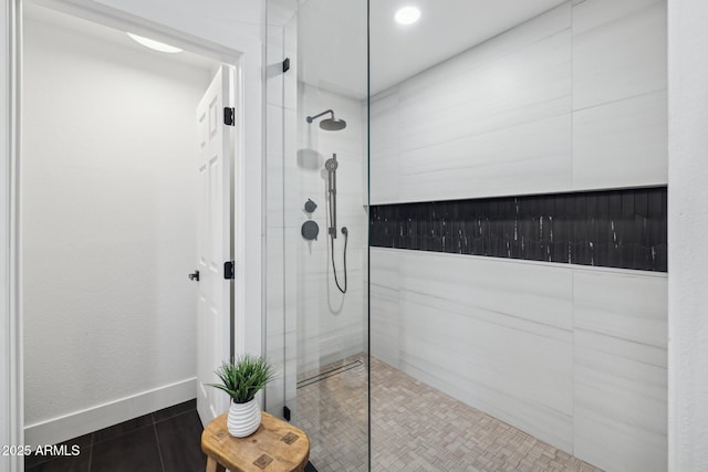 bathroom with tile patterned flooring and a tile shower