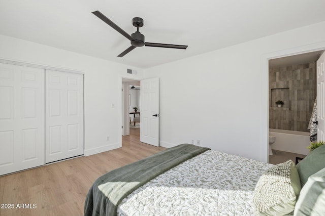 bedroom with ensuite bathroom, ceiling fan, light hardwood / wood-style floors, and a closet