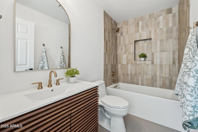 full bathroom with vanity, tiled shower / bath combo, and toilet