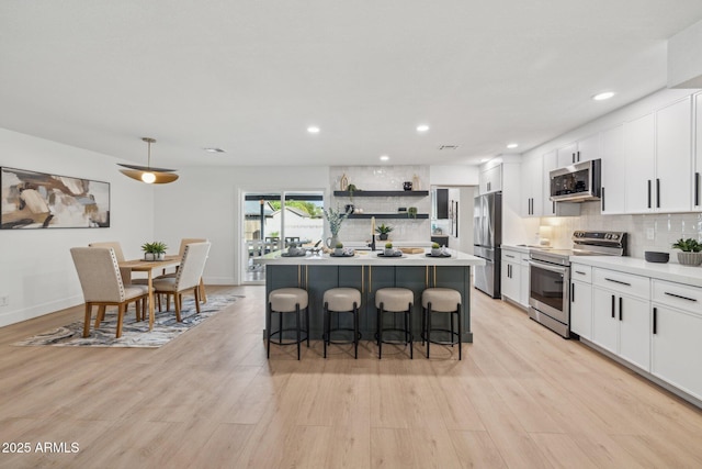 kitchen featuring stainless steel appliances, a center island, a breakfast bar area, and white cabinets