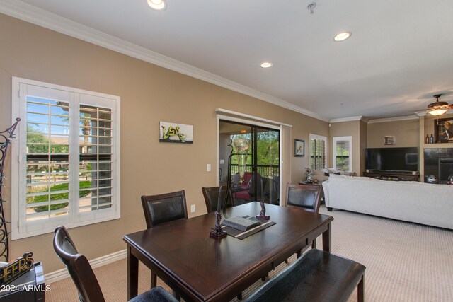 dining room featuring ornamental molding, ceiling fan, and carpet flooring