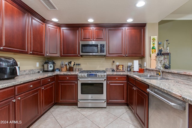 kitchen featuring light tile patterned flooring, ornamental molding, sink, and stainless steel appliances