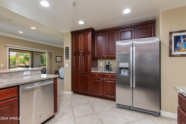 kitchen with light stone counters, appliances with stainless steel finishes, and ornamental molding