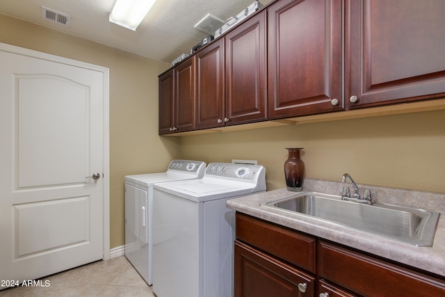 laundry room with light tile patterned floors, cabinets, sink, and independent washer and dryer