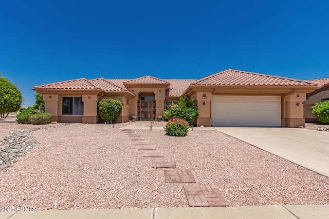 12803 W Amigo Dr, Sun City West, AZ 85375 - mediterranean / spanish-style house featuring stucco siding, a tiled roof, and a garage