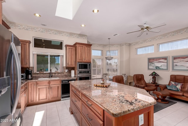 12803 W Amigo Dr, Sun City West, AZ 85375 - kitchen with appliances with stainless steel finishes, light tile patterned flooring, light stone countertops, plenty of natural light, and recessed lighting