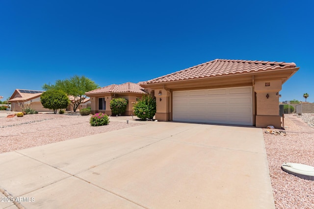 12803 W Amigo Dr, Sun City West, AZ 85375 - mediterranean / spanish house featuring a tile roof, stucco siding, an attached garage, and driveway