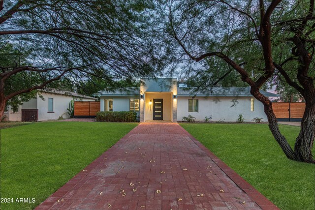 ranch-style home featuring a front lawn