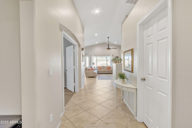 hall featuring light tile patterned floors and vaulted ceiling