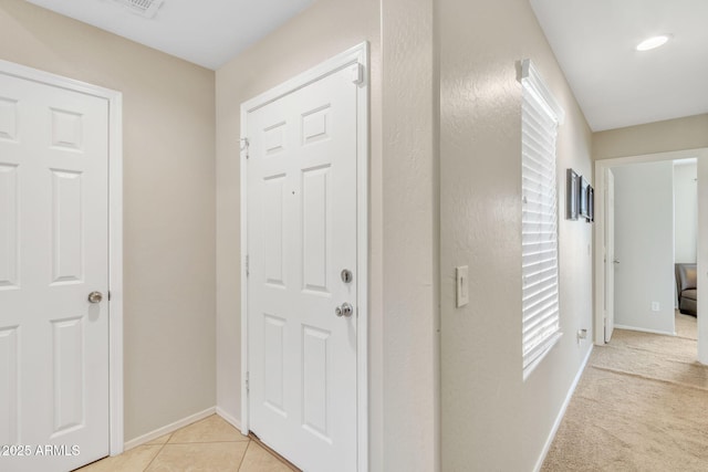 hall with light tile patterned floors