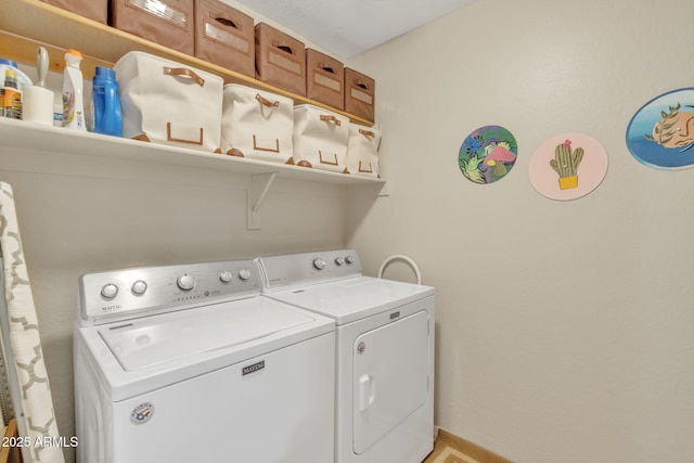 clothes washing area with washing machine and dryer