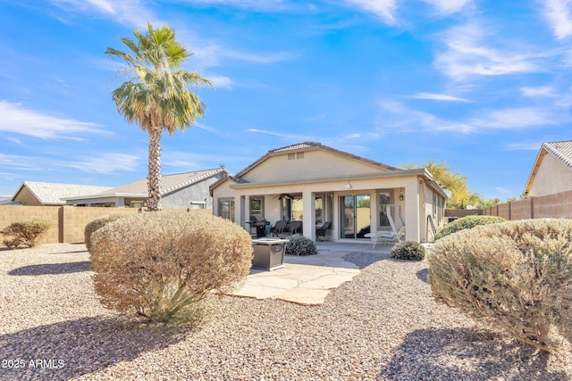 back of property featuring ceiling fan and a patio area