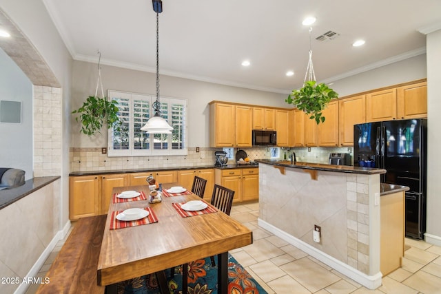 kitchen with visible vents, black appliances, an island with sink, crown molding, and decorative backsplash