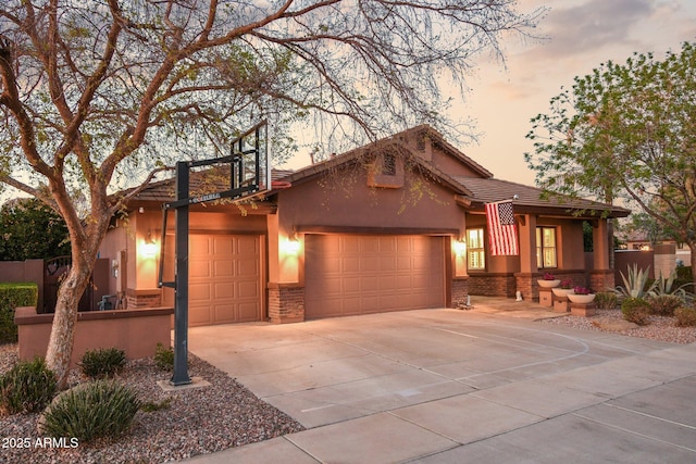 view of front facade featuring a tile roof, stucco siding, an attached garage, and concrete driveway