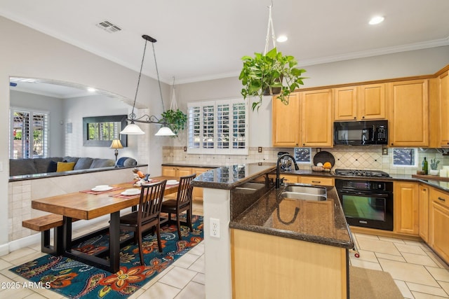 kitchen featuring visible vents, backsplash, arched walkways, black appliances, and a sink