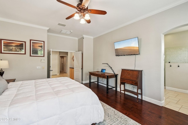 bedroom with wood finished floors, baseboards, visible vents, arched walkways, and ornamental molding