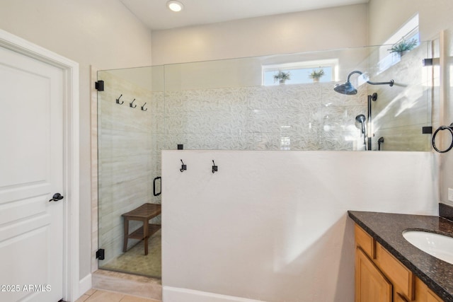 bathroom featuring a tile shower, tile patterned floors, and vanity