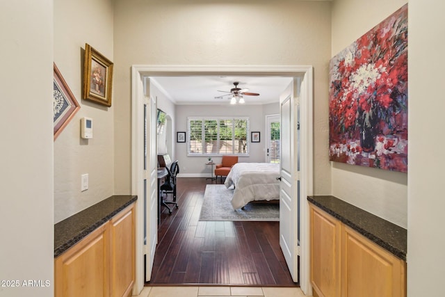 bedroom featuring a ceiling fan, crown molding, wood finished floors, and baseboards