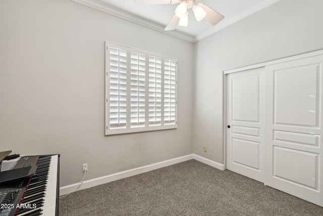 unfurnished bedroom featuring crown molding, baseboards, carpet, a closet, and a ceiling fan