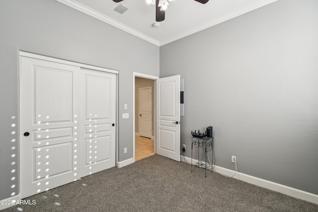 unfurnished bedroom with visible vents, baseboards, carpet, ornamental molding, and a closet