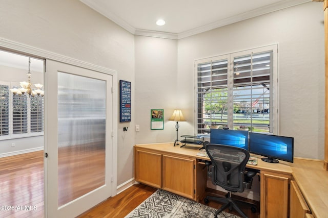 office space featuring an inviting chandelier, wood finished floors, baseboards, and ornamental molding