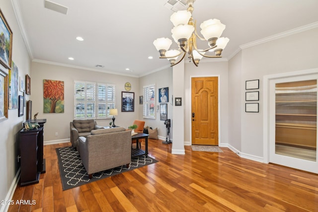 living room with crown molding, baseboards, recessed lighting, an inviting chandelier, and wood finished floors