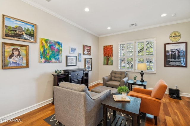 living room with visible vents, ornamental molding, baseboards, and wood finished floors