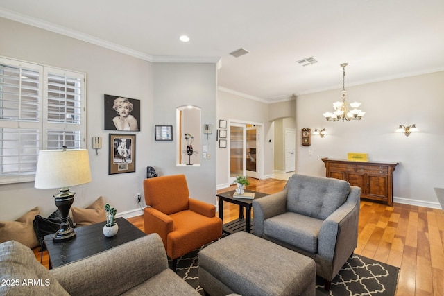 living area featuring visible vents, arched walkways, baseboards, and light wood finished floors