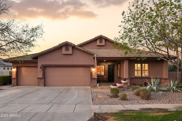 view of front facade with brick siding, stucco siding, driveway, and a garage