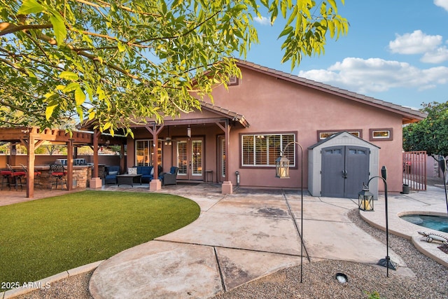 rear view of house featuring stucco siding, a patio, fence, a shed, and an outdoor structure