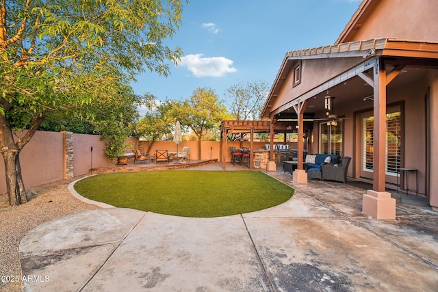 view of yard featuring an outdoor living space, ceiling fan, exterior kitchen, a fenced backyard, and a patio