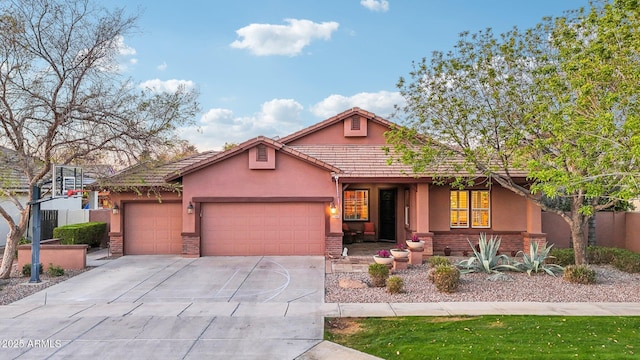 view of front of property featuring a garage, brick siding, concrete driveway, and stucco siding