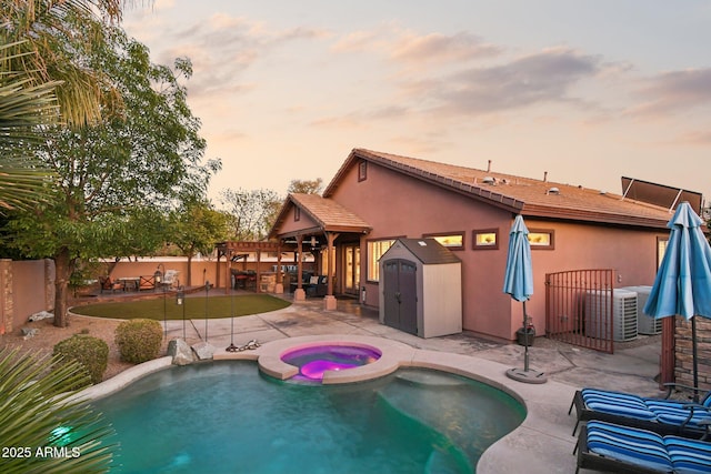 view of pool with central AC, a patio, an in ground hot tub, and a fenced backyard