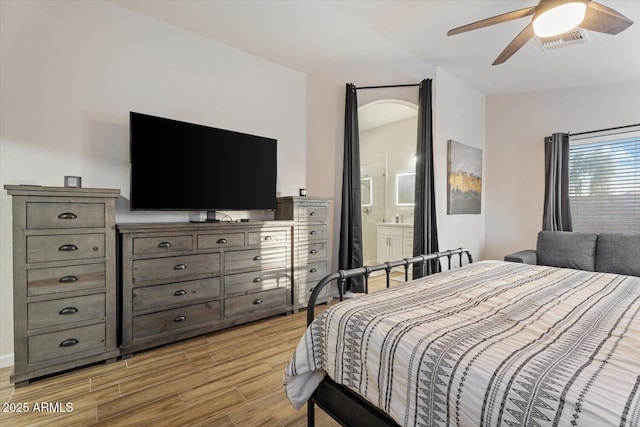 bedroom with ceiling fan, light hardwood / wood-style floors, and connected bathroom