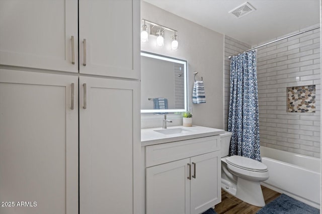 full bathroom featuring shower / bathtub combination with curtain, hardwood / wood-style floors, vanity, and toilet