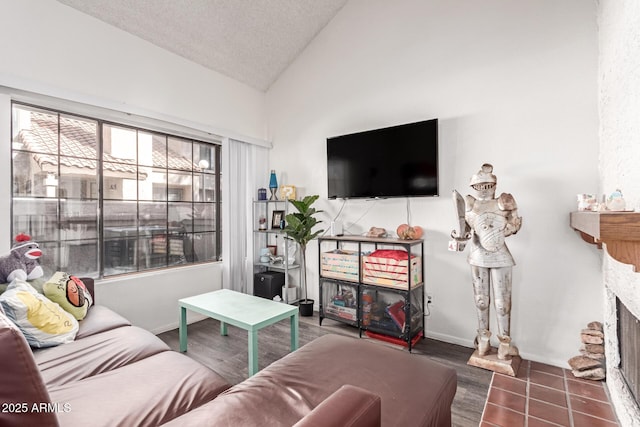 living area with lofted ceiling, a fireplace, a textured ceiling, and baseboards