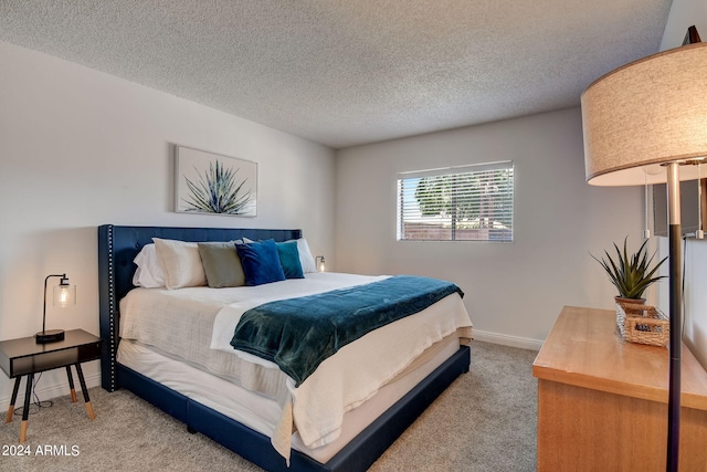 bedroom featuring a textured ceiling, baseboards, and carpet floors