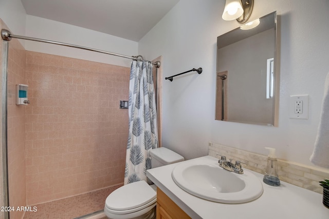 bathroom featuring toilet, vanity, and a tile shower