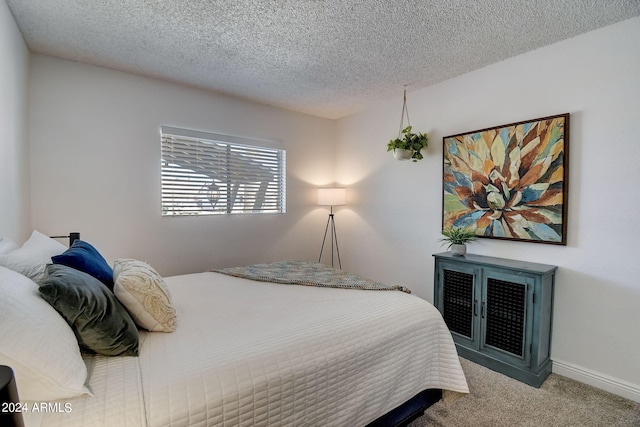 bedroom featuring baseboards, carpet floors, and a textured ceiling