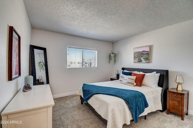 bedroom featuring baseboards, light carpet, and a textured ceiling