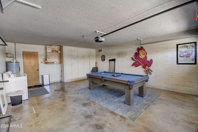 playroom with billiards, unfinished concrete floors, separate washer and dryer, water heater, and a textured ceiling