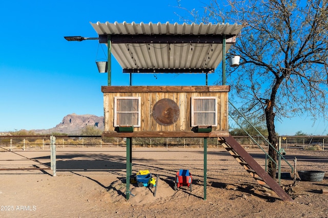 view of playground featuring a mountain view and fence
