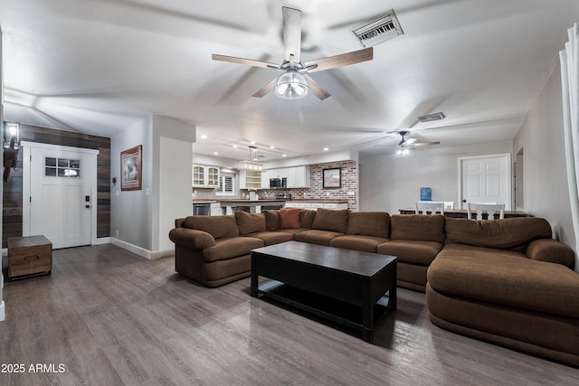 living area with ceiling fan, baseboards, wood finished floors, and recessed lighting