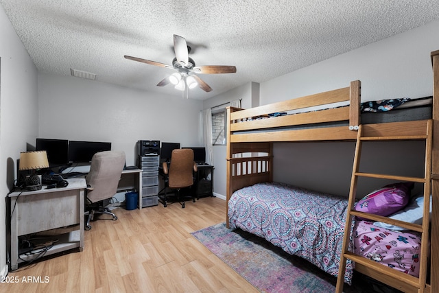 bedroom with wood finished floors, a desk, a textured ceiling, and ceiling fan