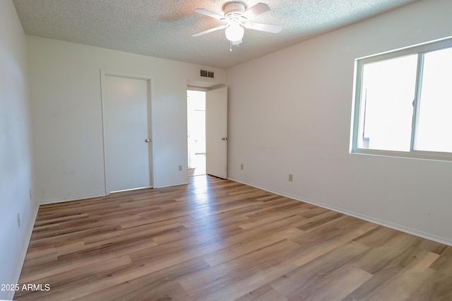 unfurnished bedroom with ceiling fan, light hardwood / wood-style flooring, and a textured ceiling