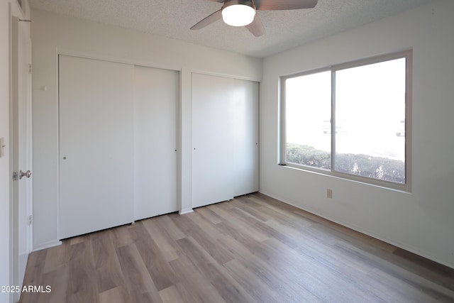 unfurnished bedroom featuring ceiling fan, light hardwood / wood-style flooring, and a textured ceiling