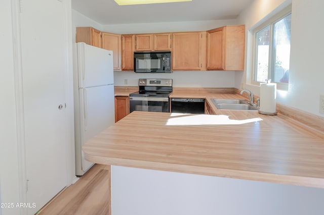 kitchen featuring sink, black appliances, kitchen peninsula, and light brown cabinets